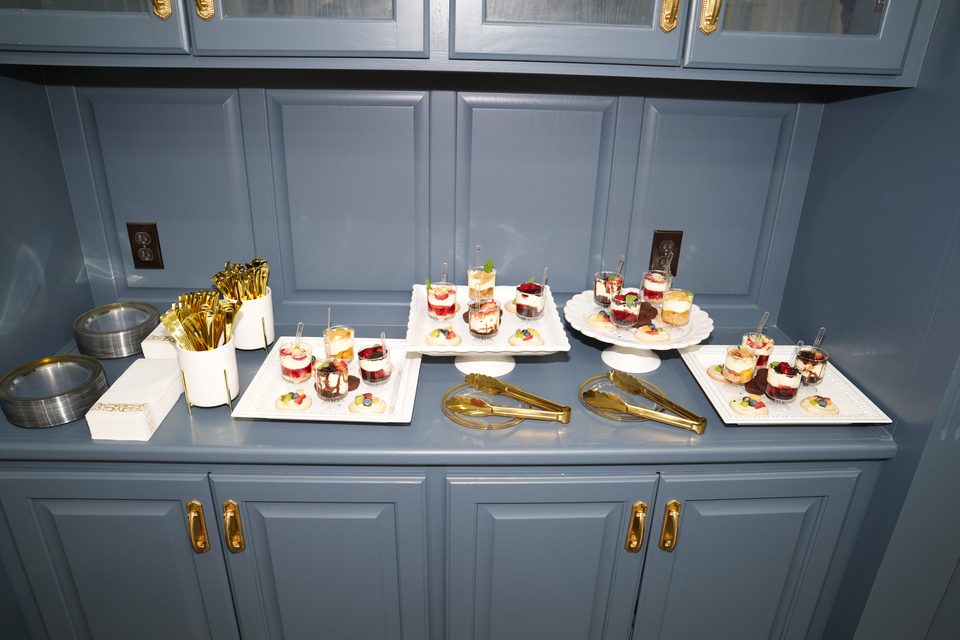 Dessert trays and gold serving tongs on the blue built in servery at Bee Cave
