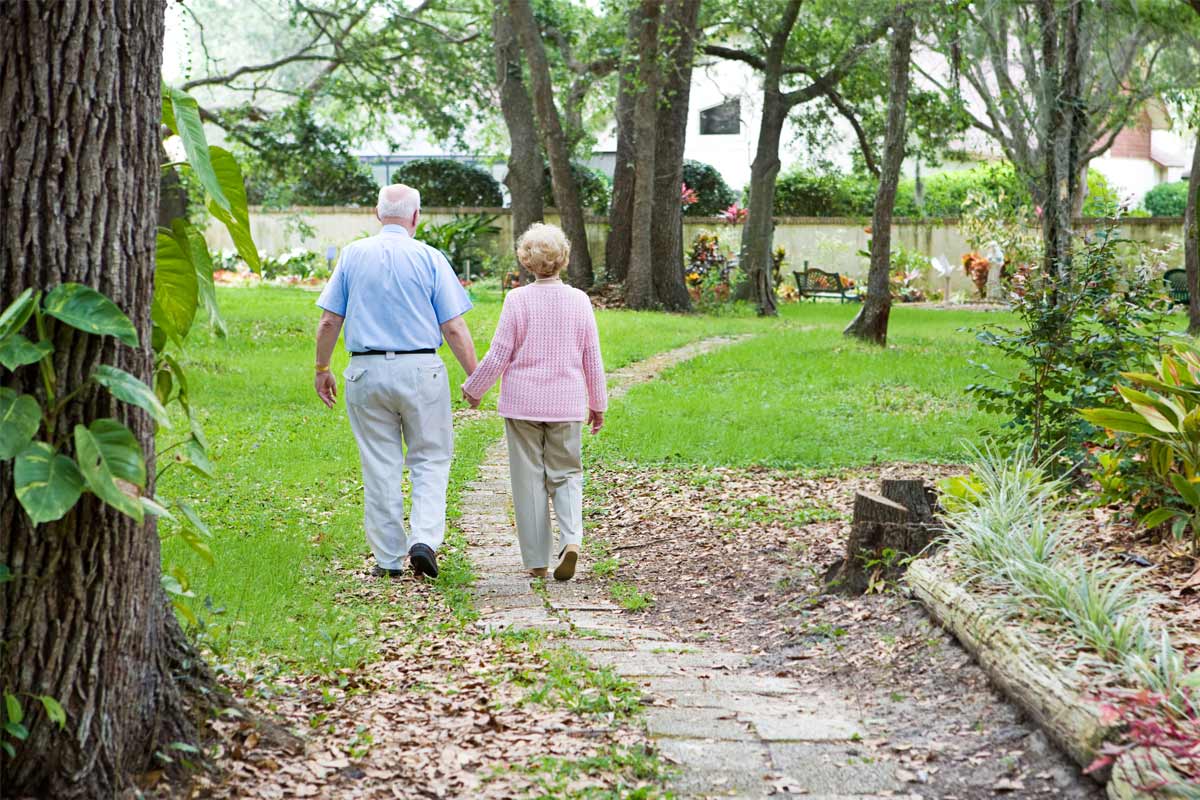 Senior couple walking down a path at a residential care home in Austin